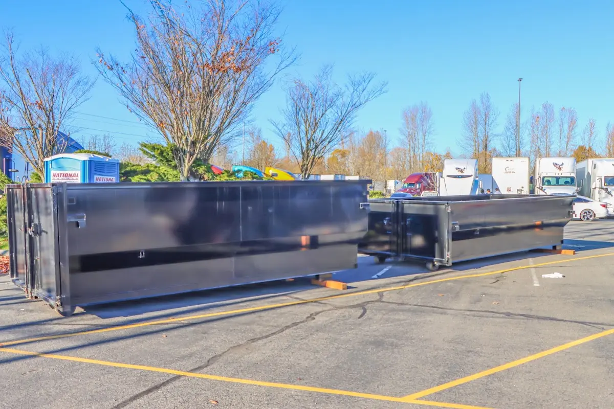 Professional dumpster rental service with roll-off container on residential driveway in Commerce